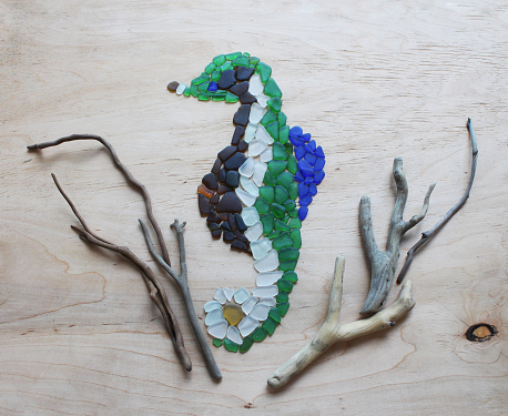 Blue, white, brown, green sea glass, stones, shells and driftwood art project