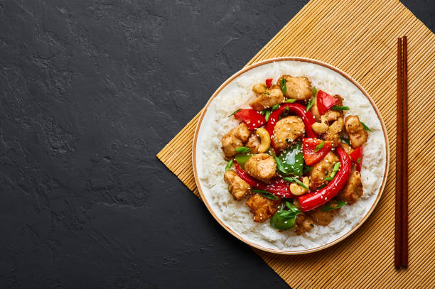 istock Schezwan Chicken or Dragon Chicken with basmati rice at black slate background. Szechuan Chicken is popular indo-chinese spicy dish with chilli peppers, chicken and vegetables. 1176607701