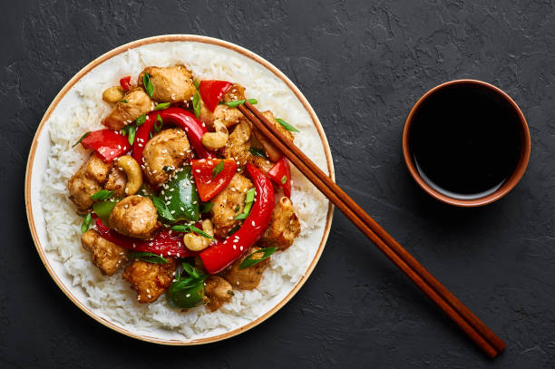 istock Schezwan Chicken or Dragon Chicken with basmati rice at black slate background. Szechuan Chicken is popular indo-chinese spicy dish with chilli peppers, chicken and vegetables. 1176608302