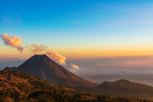 Volcan de Colima, Mexico, with clouds at sunset Image of Volcan de Colima, Mexico, at sunset taken from Nevado de Colima. fumarole photos stock pictures, royalty-free photos & images