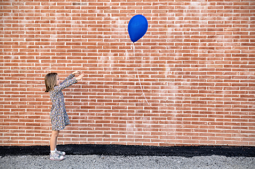 Beautiful little girl playing losing her balloon