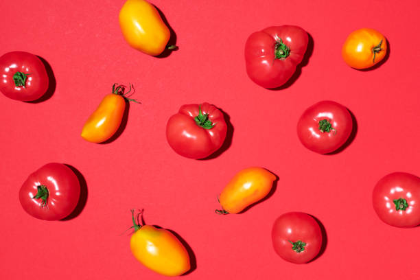 istock Yellow and red tomatoes pattern on red background. Flat lay, top view. Summer minimal concept. Vegan and vegetarian diet. 1176612878