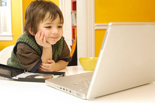 istock Happy child watching an educational DVD 117661543