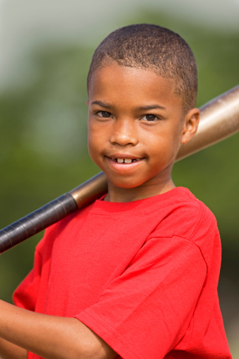 Little African American boy holding a baseball bat.
