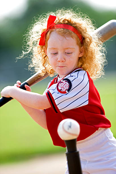 Red Haired Girl Hitting Baseball Young child ready to hit baseball. baseball hitter stock pictures, royalty-free photos & images