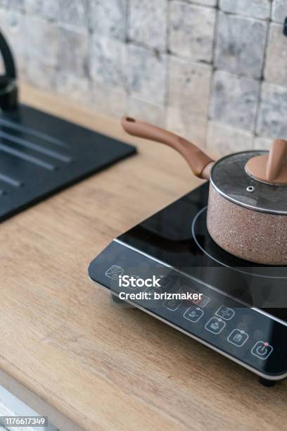 Kitchenware Pan At Small Electric Stove With Timer On Control Panel Modern  Kitchen With Wooden Surface Table And Marble Wall Tile At Blurred  Background Stock Photo - Download Image Now - iStock