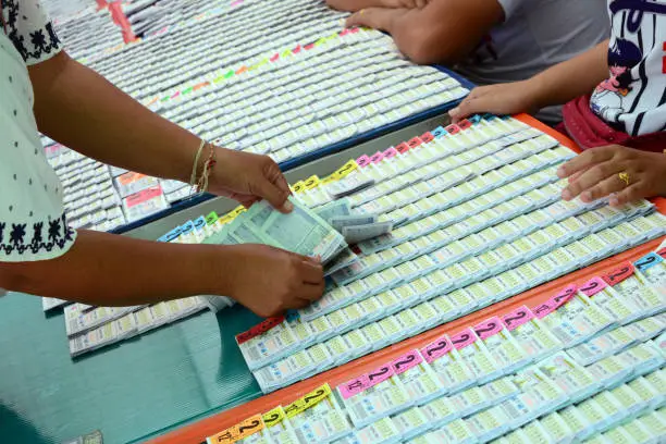 Photo of a hand of woman choose the lotto from plastic panel with many of lottery