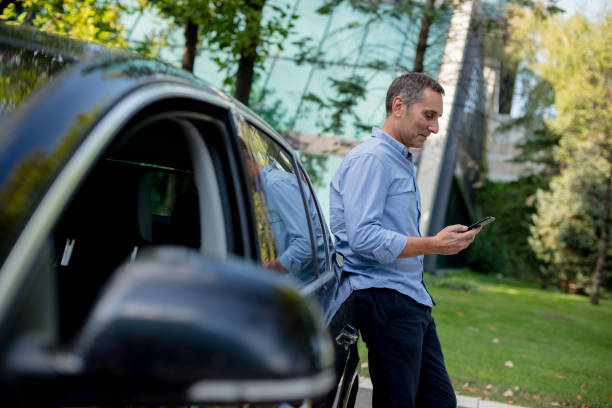 istock Casually dressed businessman using his smartphone on the parking 1176619750