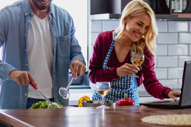 istock Young couple is preparing lunch in the kitchen using recipe from internet 1176619905