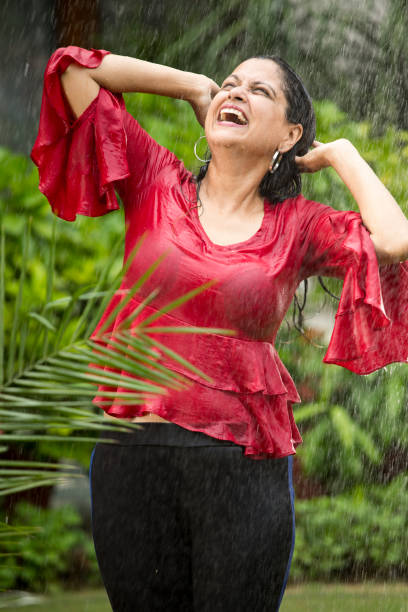 istock Indian woman enjoying rain 1176619912