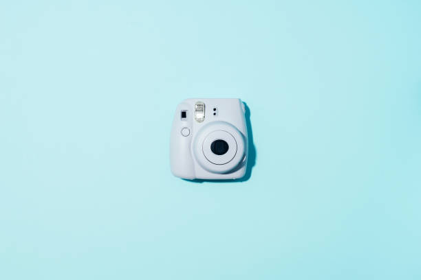 Vilnius, Lithuania - September 16, 2019: FUJIFILM INSTAX Mini Instant Film Camera on blue background. Vilnius, Lithuania - September 16, 2019: FUJIFILM INSTAX Mini Instant Film Camera on blue background looking down photos stock pictures, royalty-free photos & images