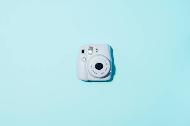 vilnius, lituânia-16 de setembro de 2019: fujifilm instax mini câmera instantânea da película no fundo azul. - looking down fotos - fotografias e filmes do acervo