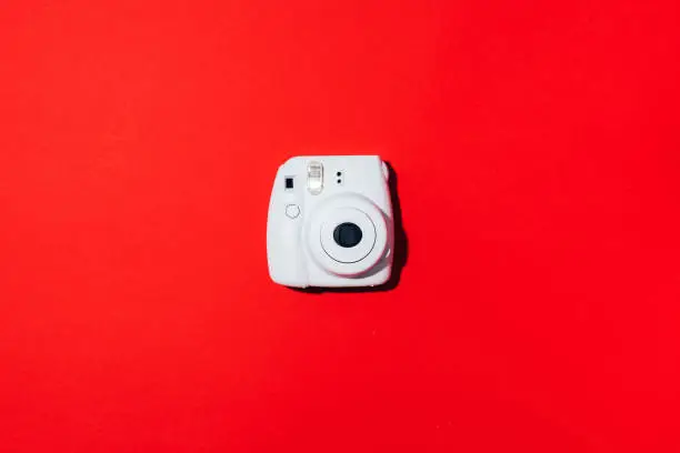 Vilnius, Lithuania - September 16, 2019: FUJIFILM INSTAX Mini Instant Film Camera on red background