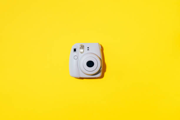 vilnius, litauen - 16. september 2019: fujifilm instax mini instant film camera auf gelbem hintergrund. - studio shot flash stock-fotos und bilder