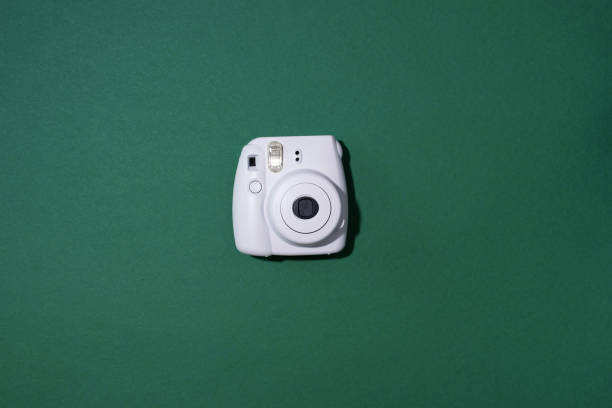vilnius, lithuania - september 16, 2019: fujifilm instax mini instant film camera on green background. - editorial use flash imagens e fotografias de stock