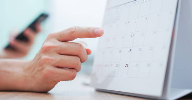 close up on employee man hand using finger pointing schedule (timetable) on calendar to make appointment meeting or manage timetable each day , life balance concept close up on employee man hand using finger pointing schedule (timetable) on calendar to make appointment meeting or manage timetable each day , life balance concept month photos stock pictures, royalty-free photos & images