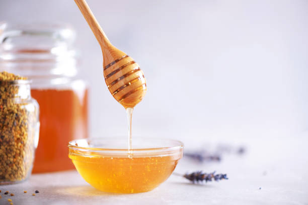 istock Bee pollen granules, honey jar with wooden dropper, honeycomb on grey backdrop. Copy space. Autumn harvest concept 1176623907