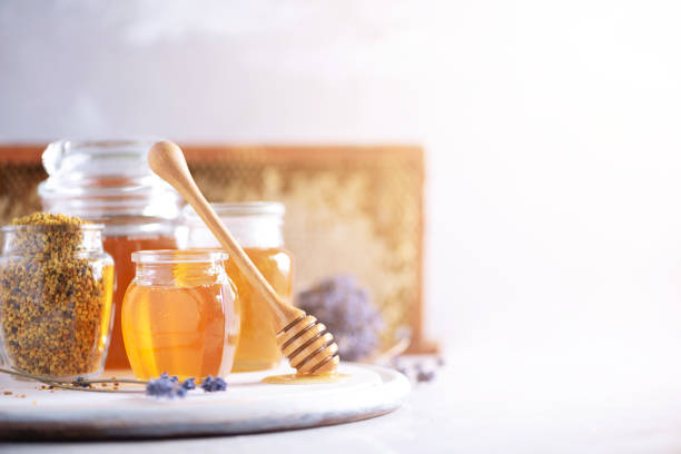istock Bee pollen granules, honey jar with wooden dropper, honeycomb on grey backdrop. Copy space. Autumn harvest concept 1176623910