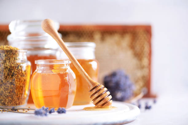 istock Bee pollen granules, honey jar with wooden dropper, honeycomb on grey backdrop. Copy space. Autumn harvest concept 1176623941