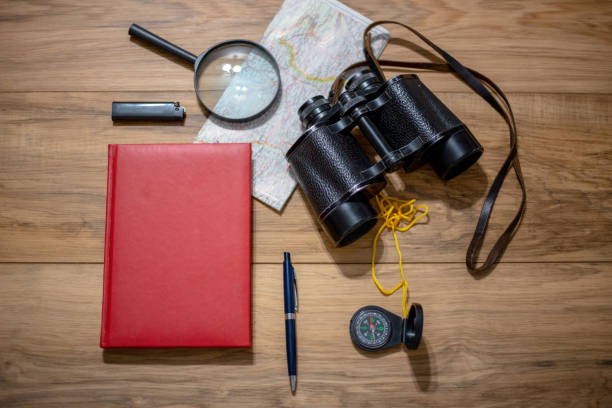 istock Old notebook, compass, map, vintage binoculars, magnifying glass on wooden background 1176623988