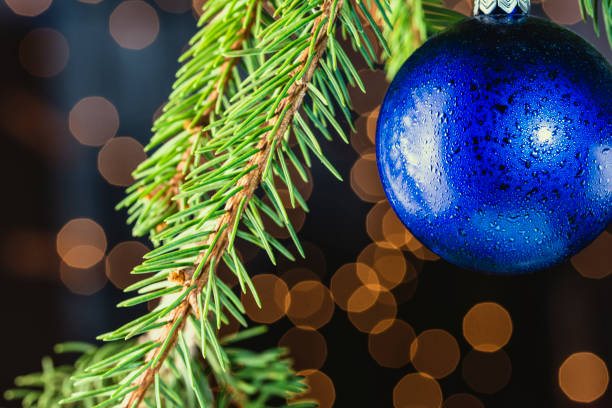 istock Blue christmas ornament on tree with bokeh background, christmas image with copy space 1176628234