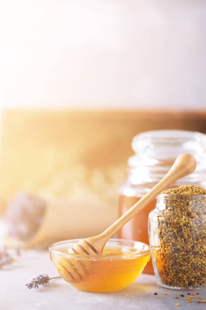 istock Bee pollen granules, honey jar with wooden dropper, honeycomb on grey backdrop. Copy space. Autumn harvest concept 1176629889