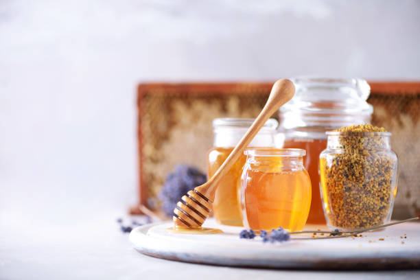 istock Bee pollen granules, honey jar with wooden dropper, honeycomb on grey backdrop. Copy space. Autumn harvest concept 1176629924