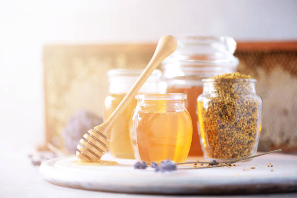 istock Bee pollen granules, honey jar with wooden dropper, honeycomb on grey backdrop. Copy space. Autumn harvest concept 1176629936