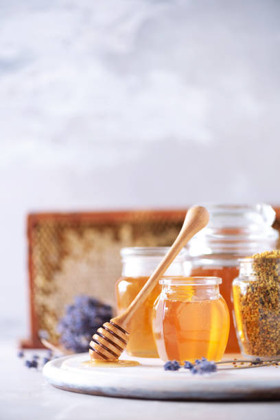 istock Bee pollen granules, honey jar with wooden dropper, honeycomb on grey backdrop. Copy space. Autumn harvest concept 1176629943