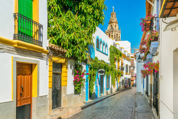 malerische randanschauung im malerischen jüdischen viertel von cordoba mit dem glockenturm der moscheekathedrale. andalusien, spanien. - andalusien stock-fotos und bilder