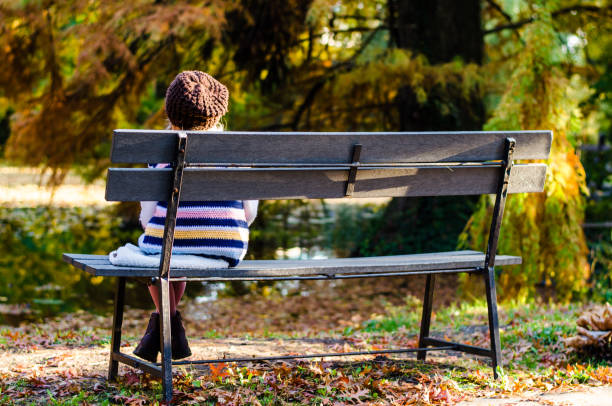 istock little lonely child sitting in the bench alone back view 1176630588