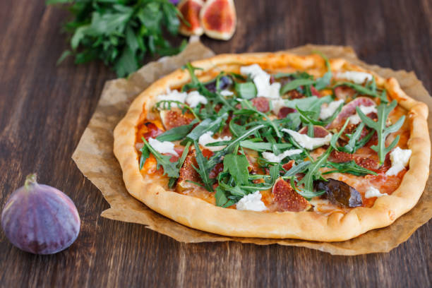 Pizza with figs, prosciutto,cheese and arugula.selective focus