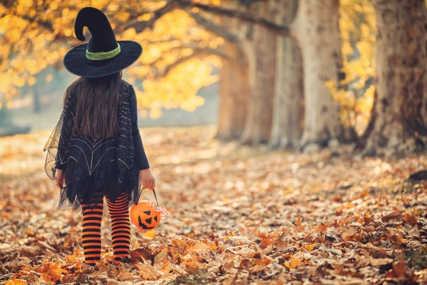 little girl in witch costume having fun on halloween trick or treat - halloween witchs hat witch autumn imagens e fotografias de stock