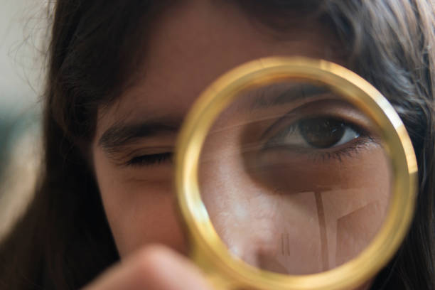 istock Little girl kid looking through magnifying glass. 1176637496