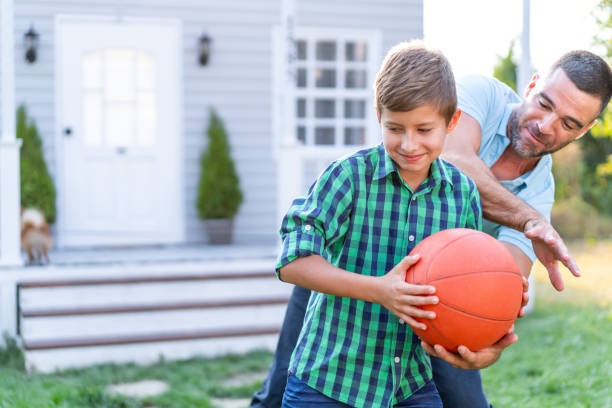 istock Father And Son Playing Basketball in front of front yard 1176638519