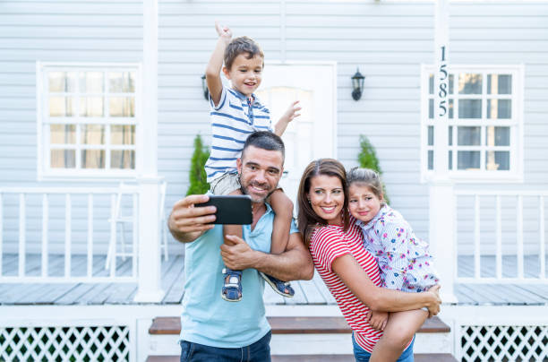 istock Parents having fun in front yard carrying children piggyback 1176638537