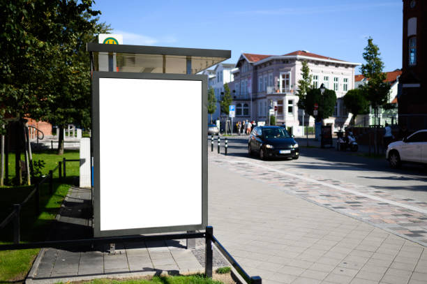 Blank bus stop 6-sheet or billboard advertising template with copy space shot on a sunny day with blue sky Blank bus stop advertising poster shot in Germany near Rostock at a bus stop. Perfect for visualising design or advertising concepts bus shelter stock pictures, royalty-free photos & images