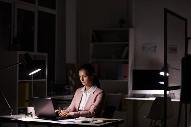 istock Woman working in dark office 1176640120