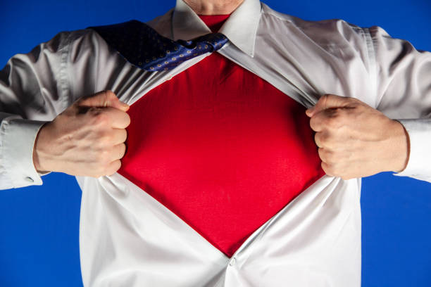 бизнесмен срывает костюм на синем фоне, мужчина толкает рубашку красной футболкой. супергерой. - shirt fully unbuttoned men torso стоковые фото и изображения