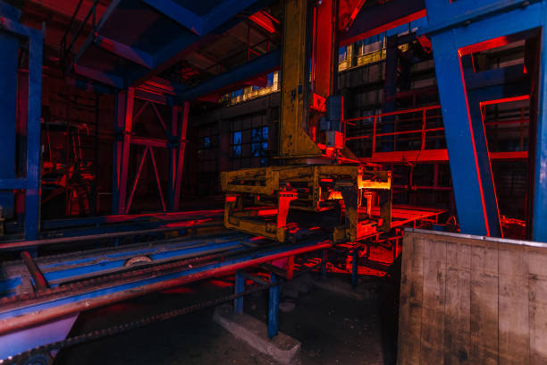 istock Abandoned brick factory at night. Old rusty brick forming machine and conveyor illuminated by color light. Abstract industrial background 1176641944