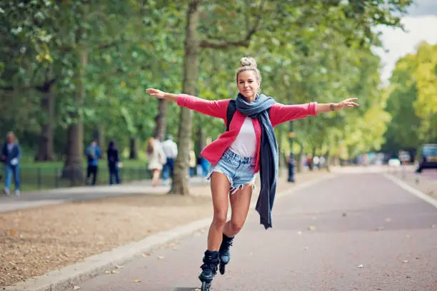 Happy tourist girl is skating on the street