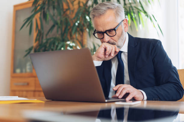 istock Middle-aged businessman working on laptop at desk 1176642506