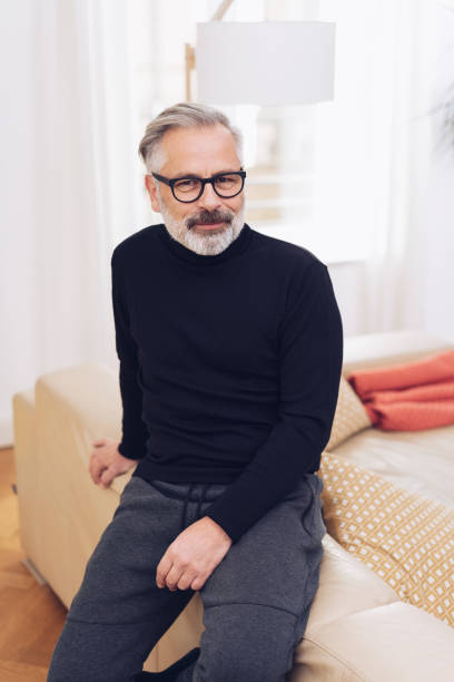 istock Middle-aged man in black sweater at home 1176642633