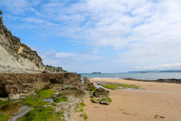 istock Rocks at the end of sardinero beach with some clouds. 1176643329