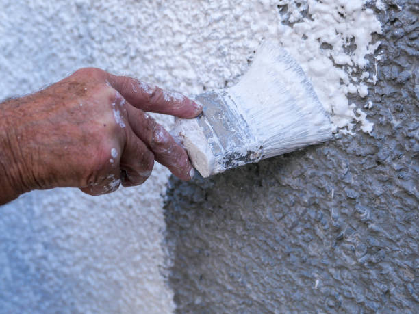 um pintor e um decorador que pintam o roughcast novo, pebbledash - bristle brush part - fotografias e filmes do acervo