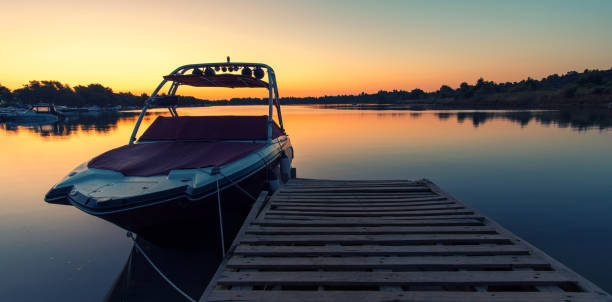 bateau près d'une jetée au lever de soleil - motorboat nautical vessel speedboat lake photos et images de collection