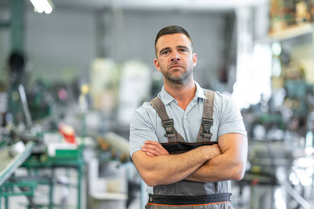 istock Foreman standing in factory with arms crossed 1176647771