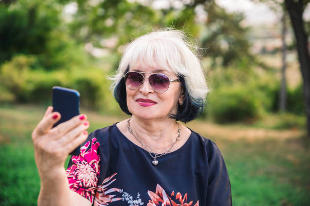 istock Senior Woman using mobile phone outdoor. 1176647852