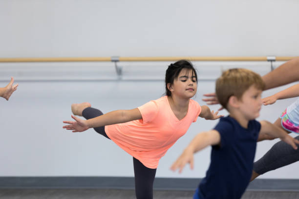 istock Elementary age girl holding pose in yoga class 1176648434