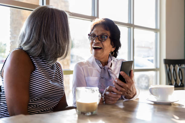 istock Two female senior friends share laugh over coffee 1176649338